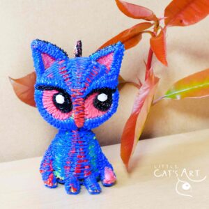 Small blue cat figure with pink eyes
