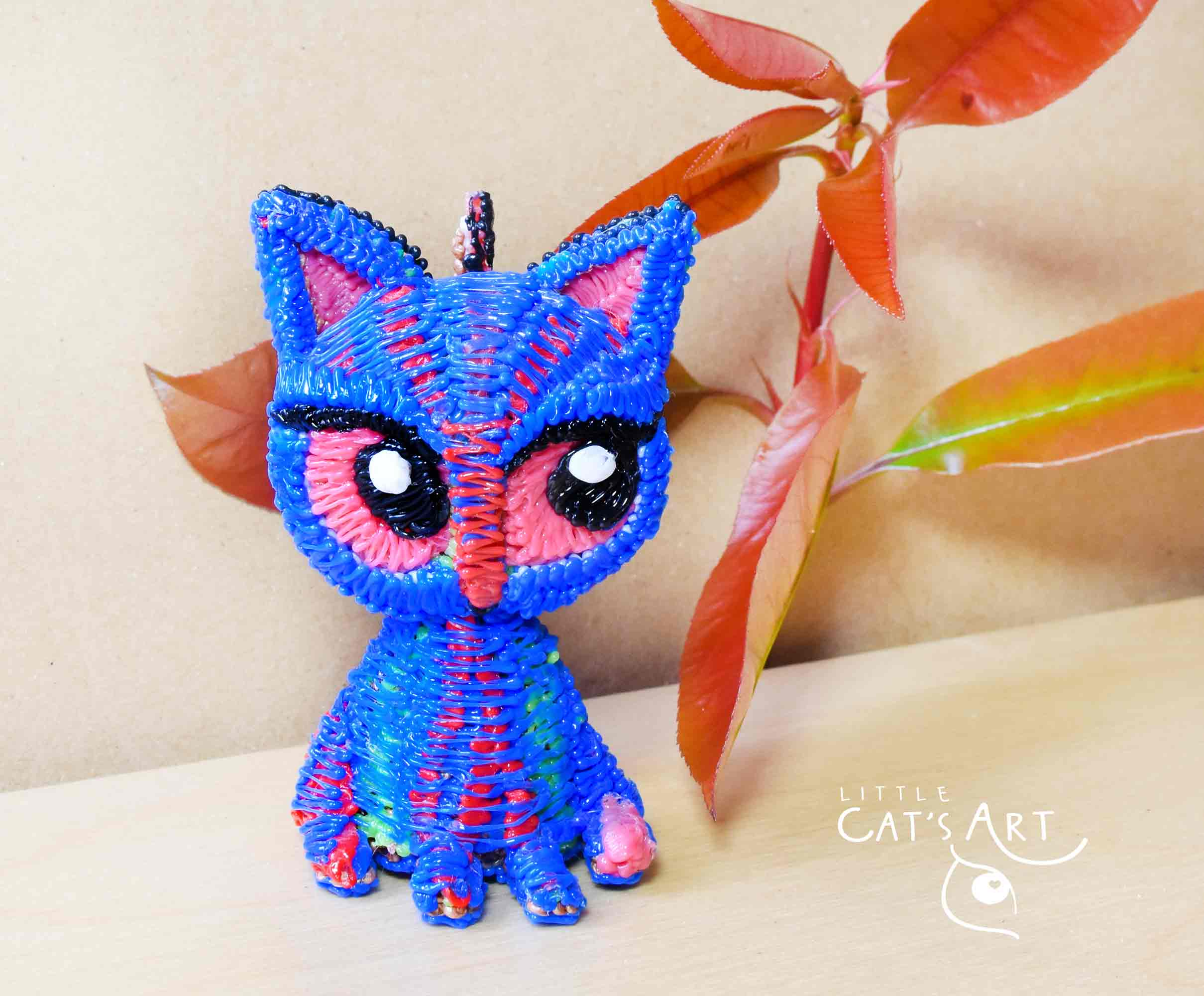 Small blue cat figure with pink eyes