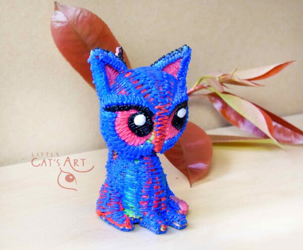 Small blue cat figure with pink eyes