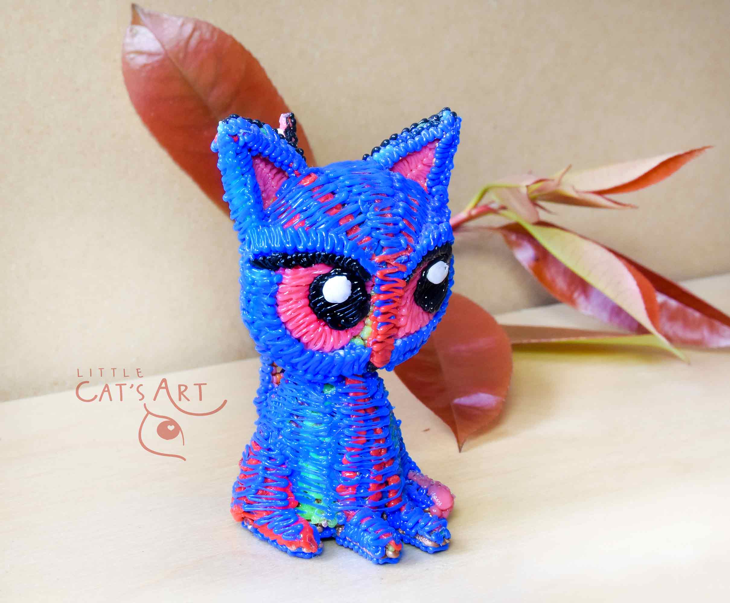 Small blue cat figure with pink eyes
