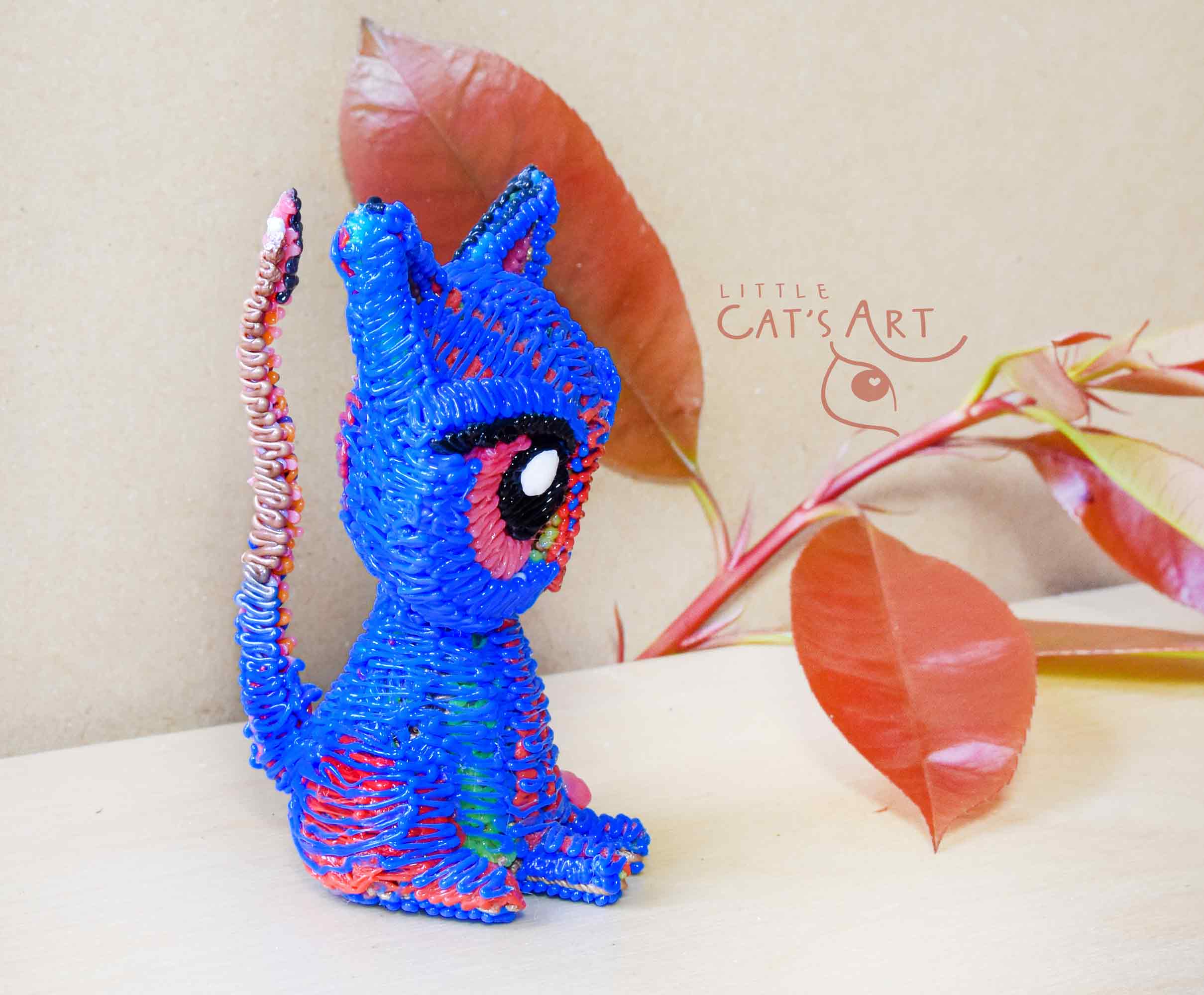 Small blue cat figure with pink eyes
