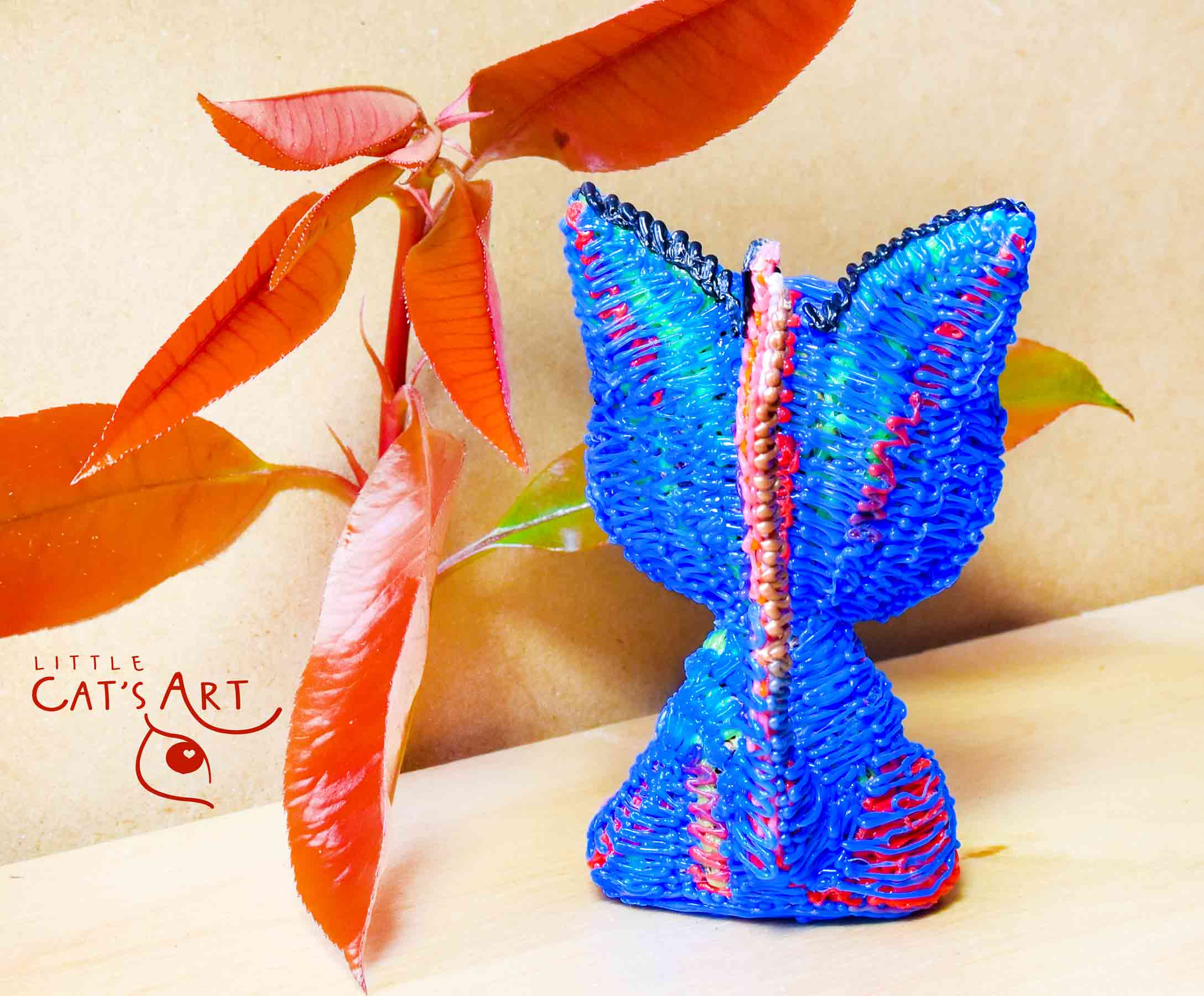 Small blue cat figure with pink eyes