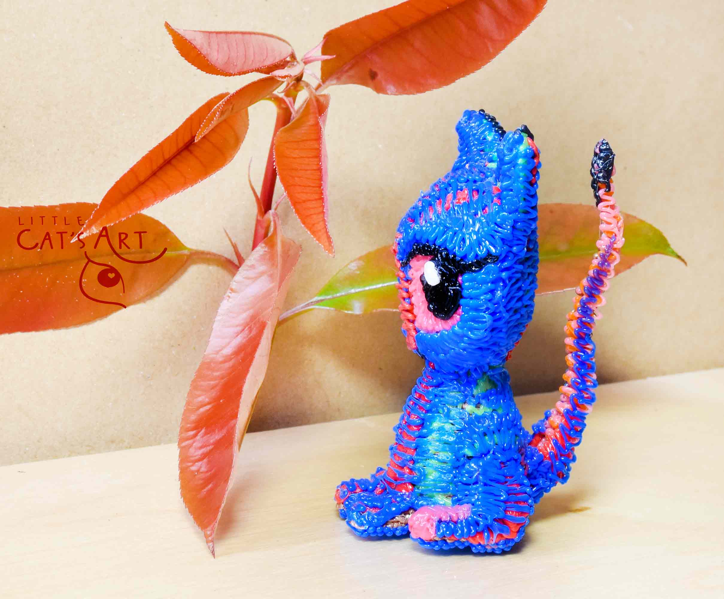 Small blue cat figure with pink eyes
