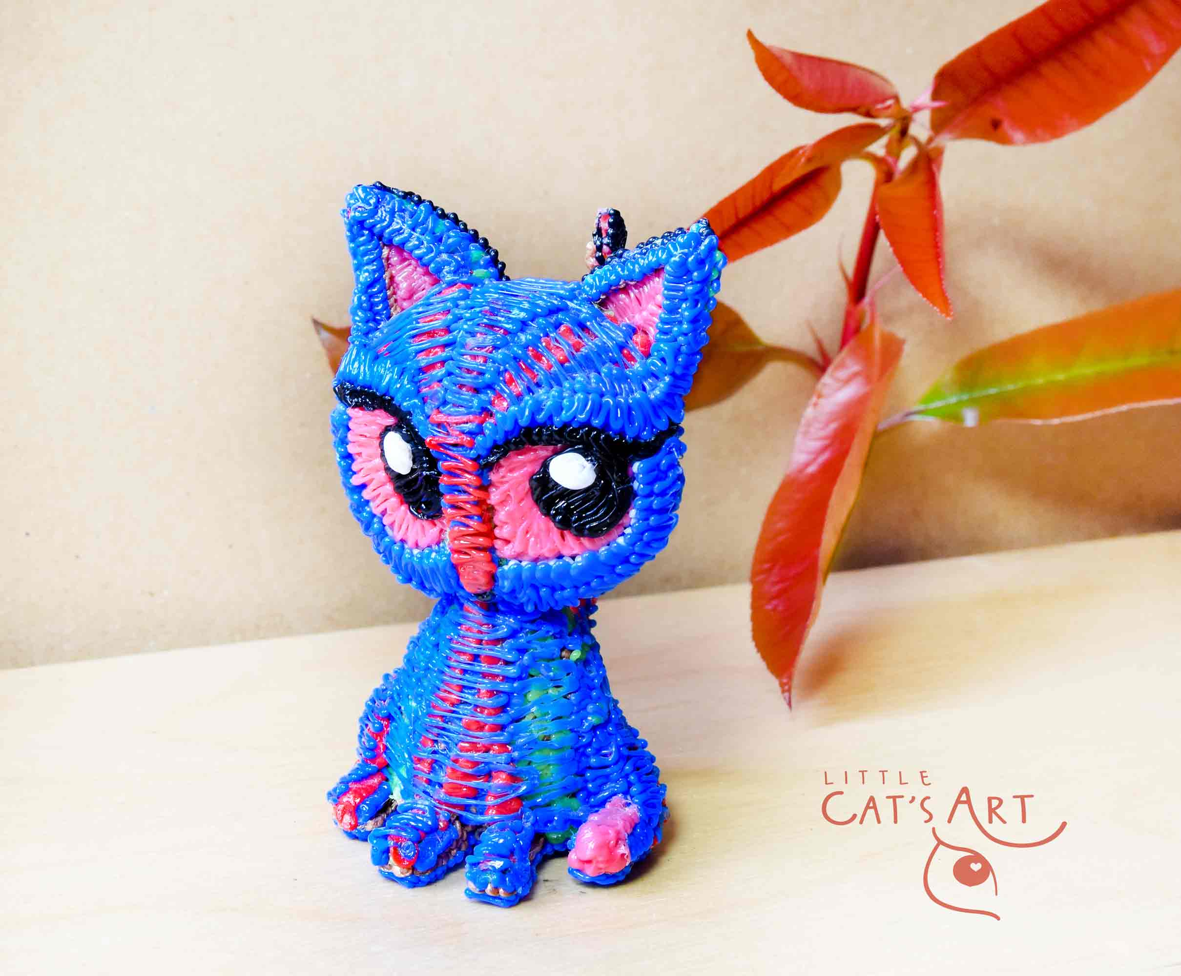 Small blue cat figure with pink eyes