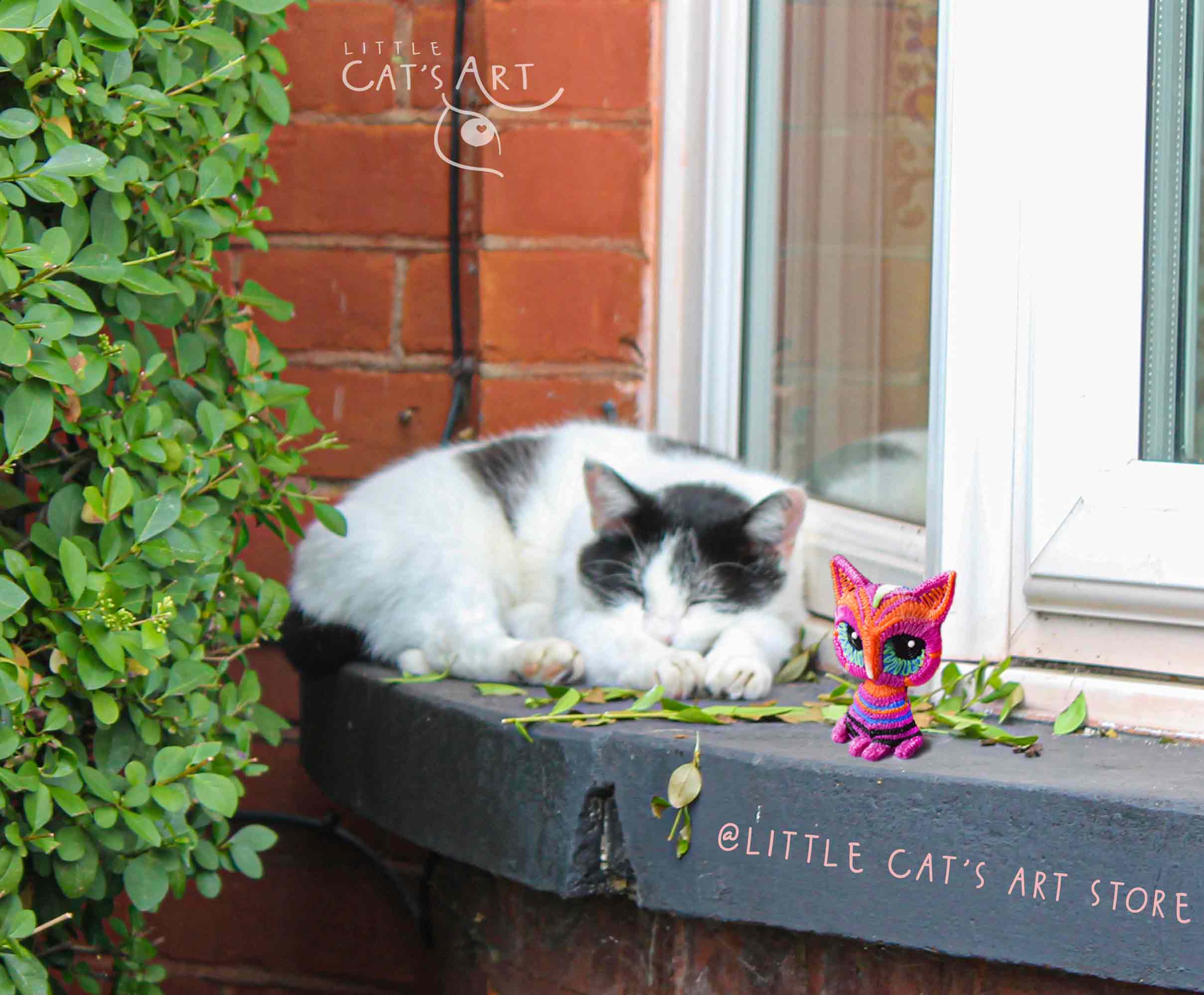 Pink striped cat figurine and Tuxedo cat