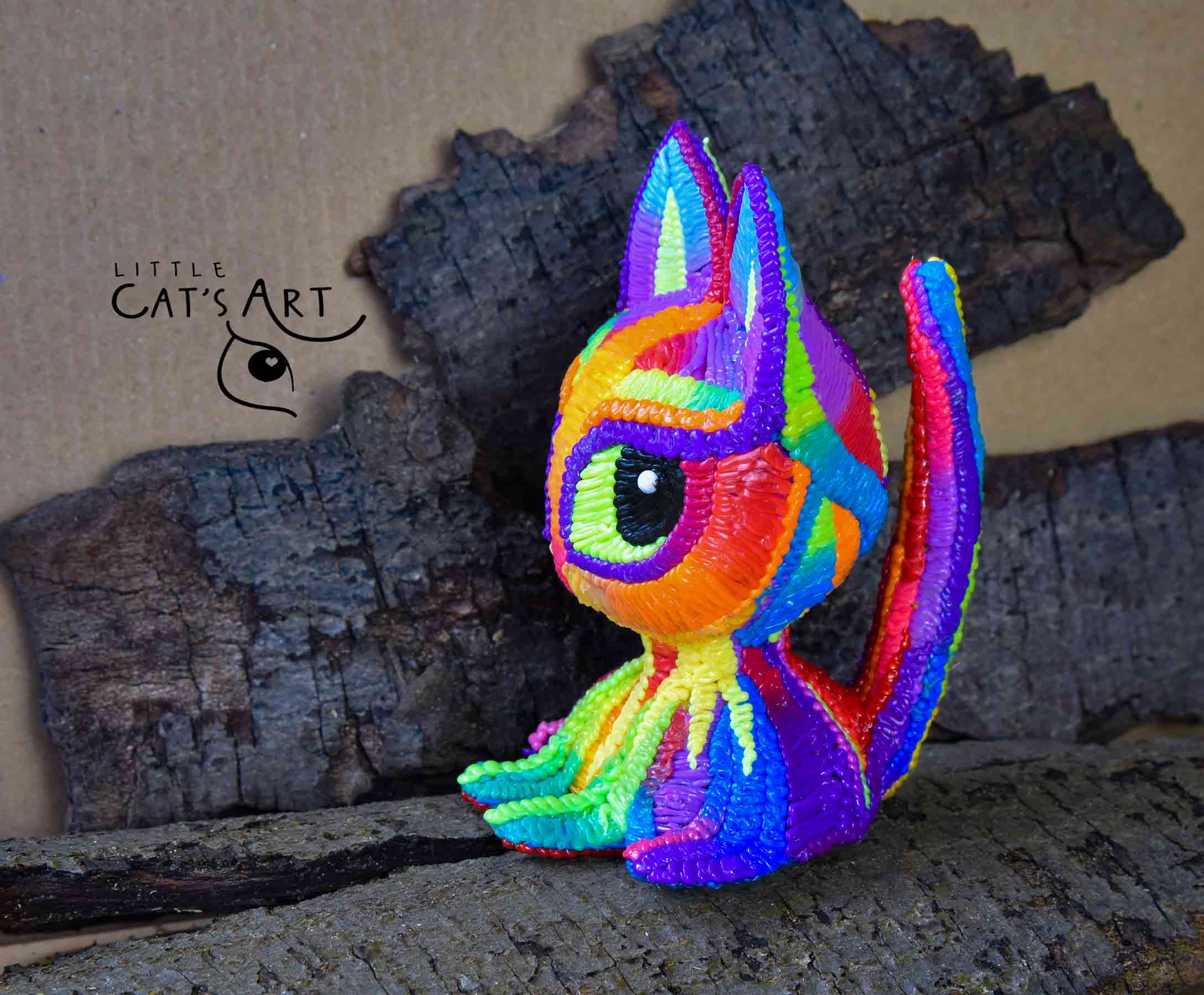 Rainbow cat figurine with bright green eyes