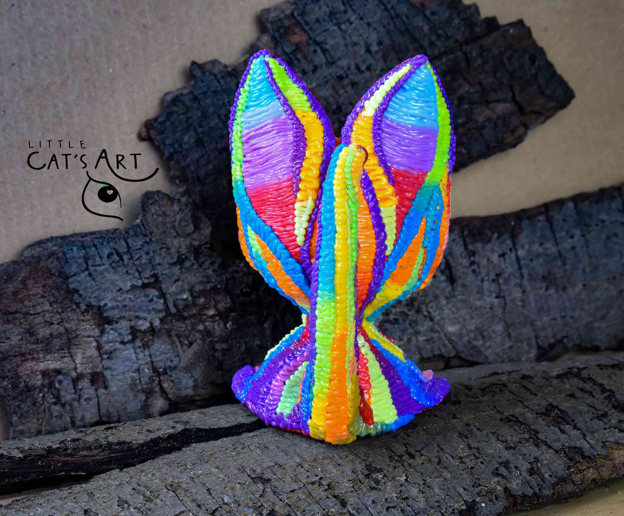 Rainbow cat figurine with bright green eyes
