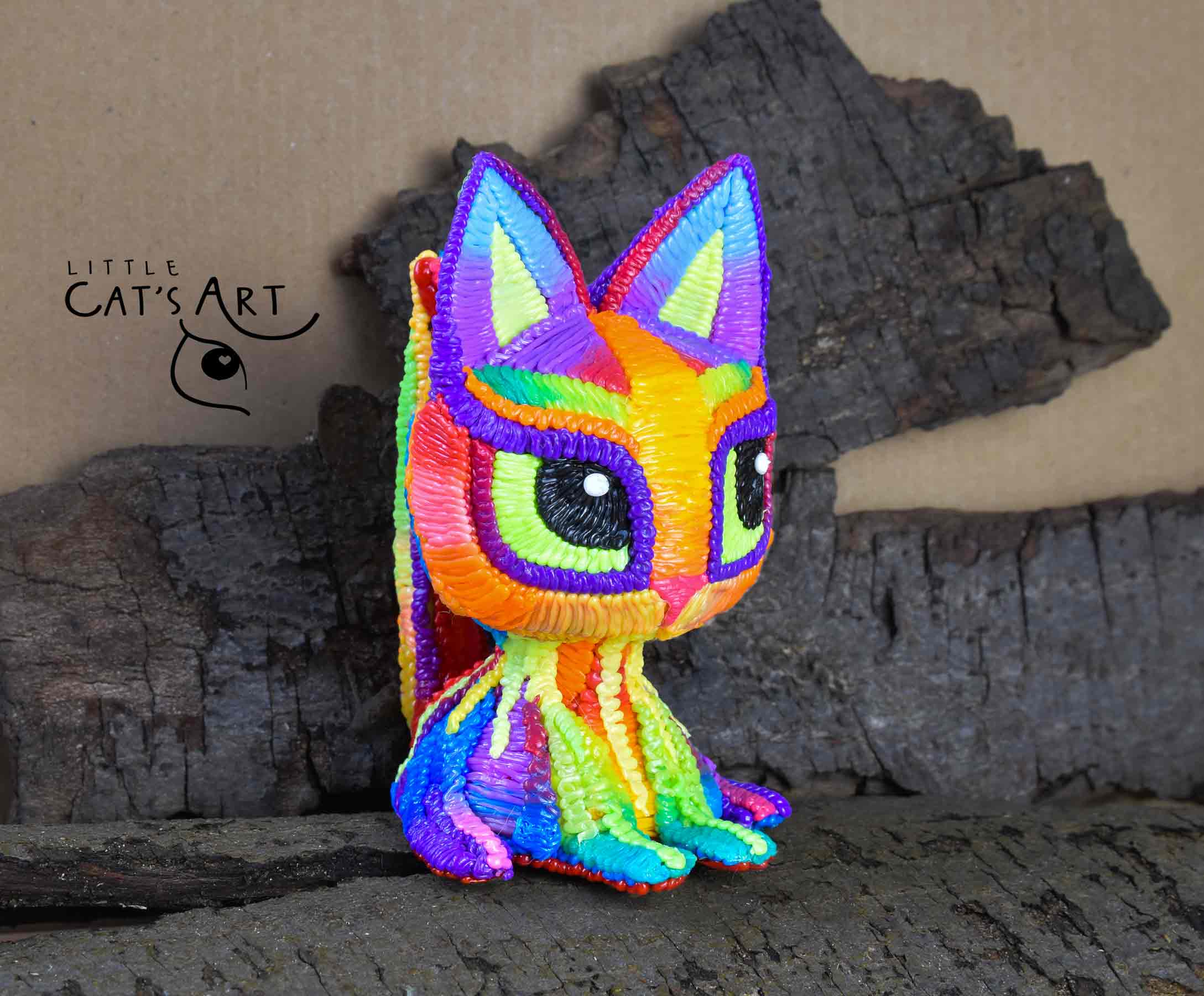 Rainbow cat figurine with bright green eyes