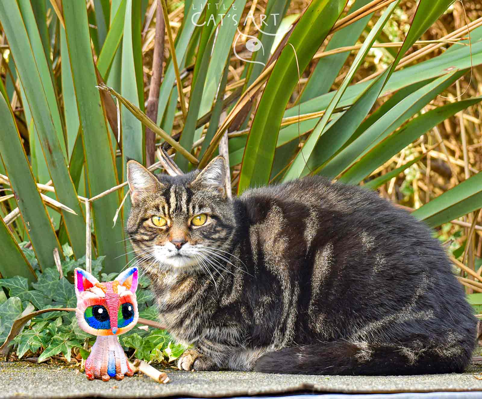 White rainbow cat figure and tabby cat