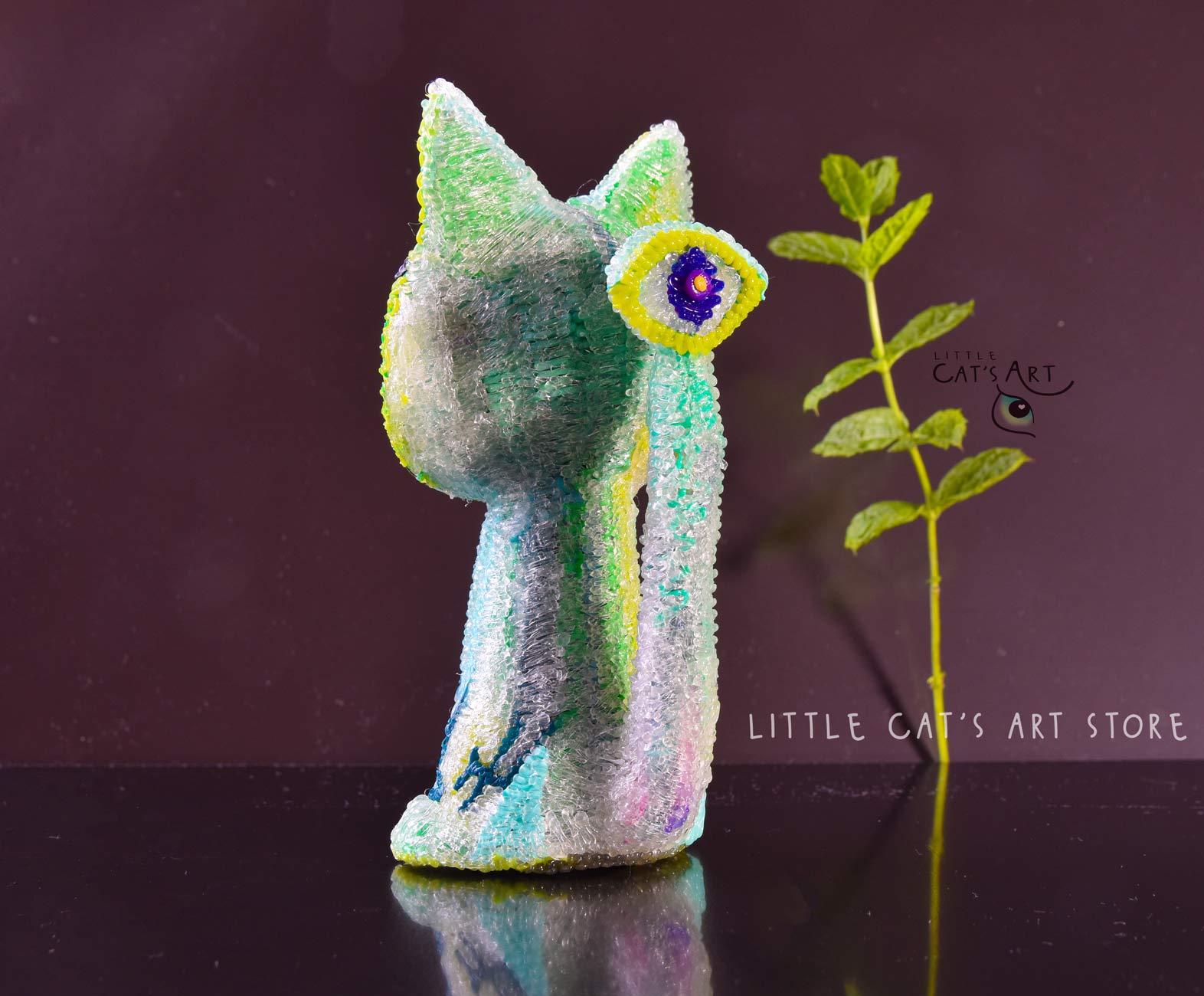 Green mint alien cat figurine with 1 eye on the tail