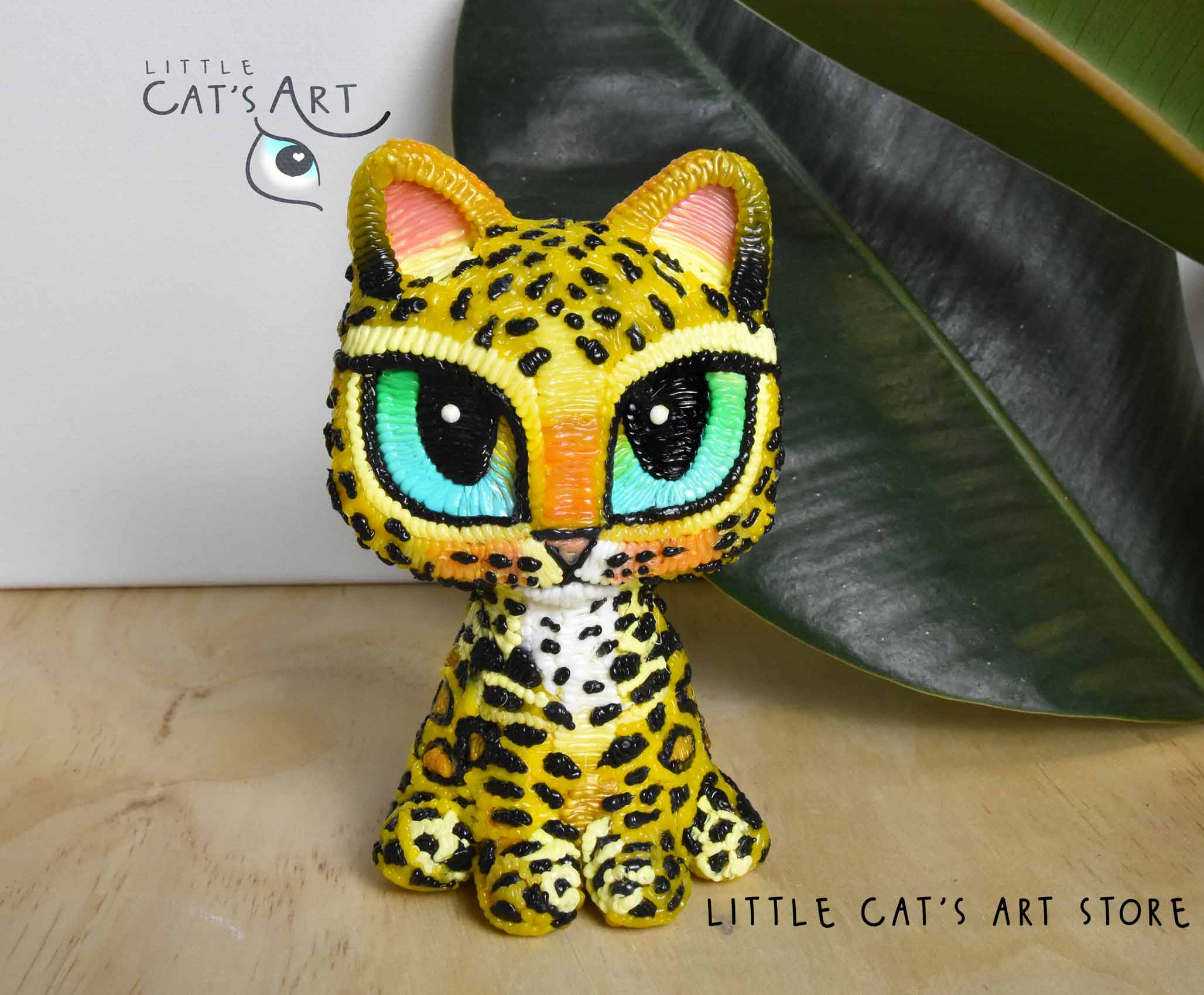Leopard cat figurine with green-blue eyes