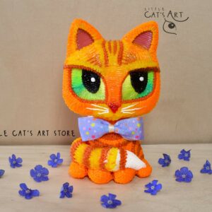 Ginger cat with green eyes wearing a bow tie