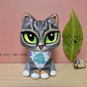 grey striped cat figurine wearing a bandana