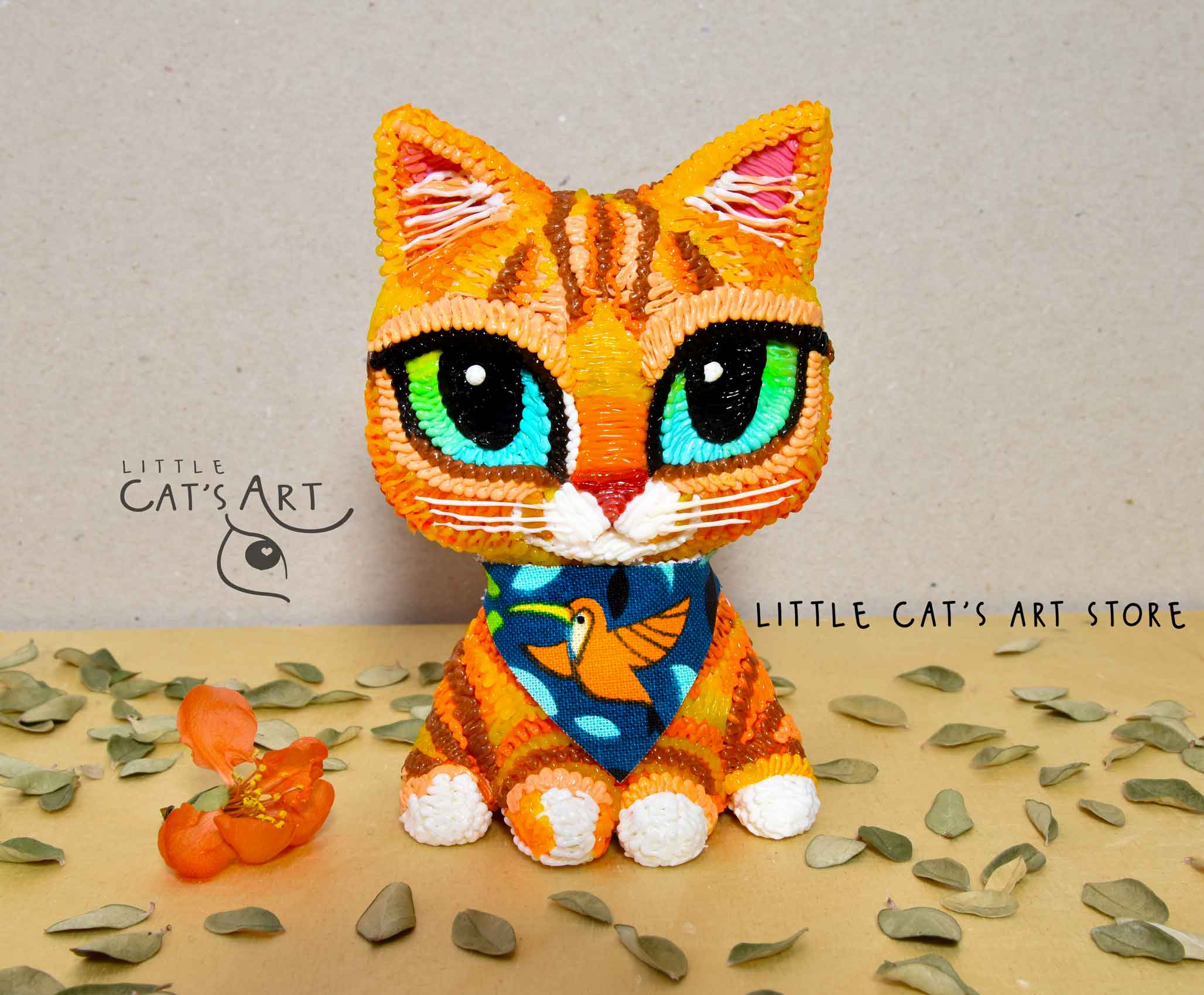 Ginger kitty figurine with green eyes wearing bandana illustrating bird