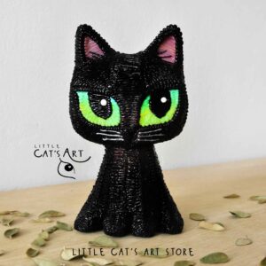 Black cat figurine with green eyes