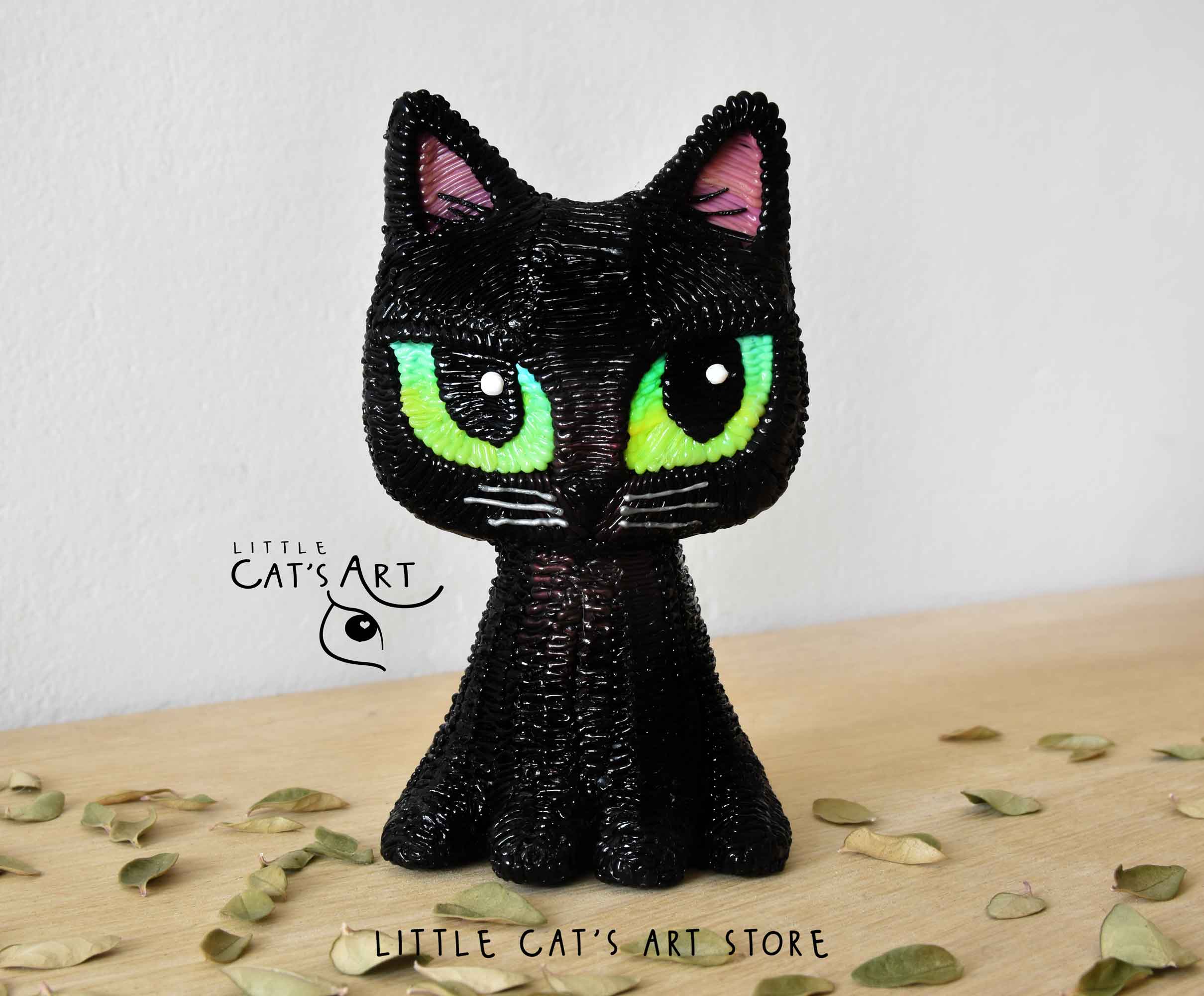 Black cat figurine with green eyes