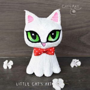 White cat figurine with red bow tie