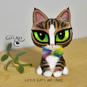 Tabby and white cat with green eyes and rainbow bowtie