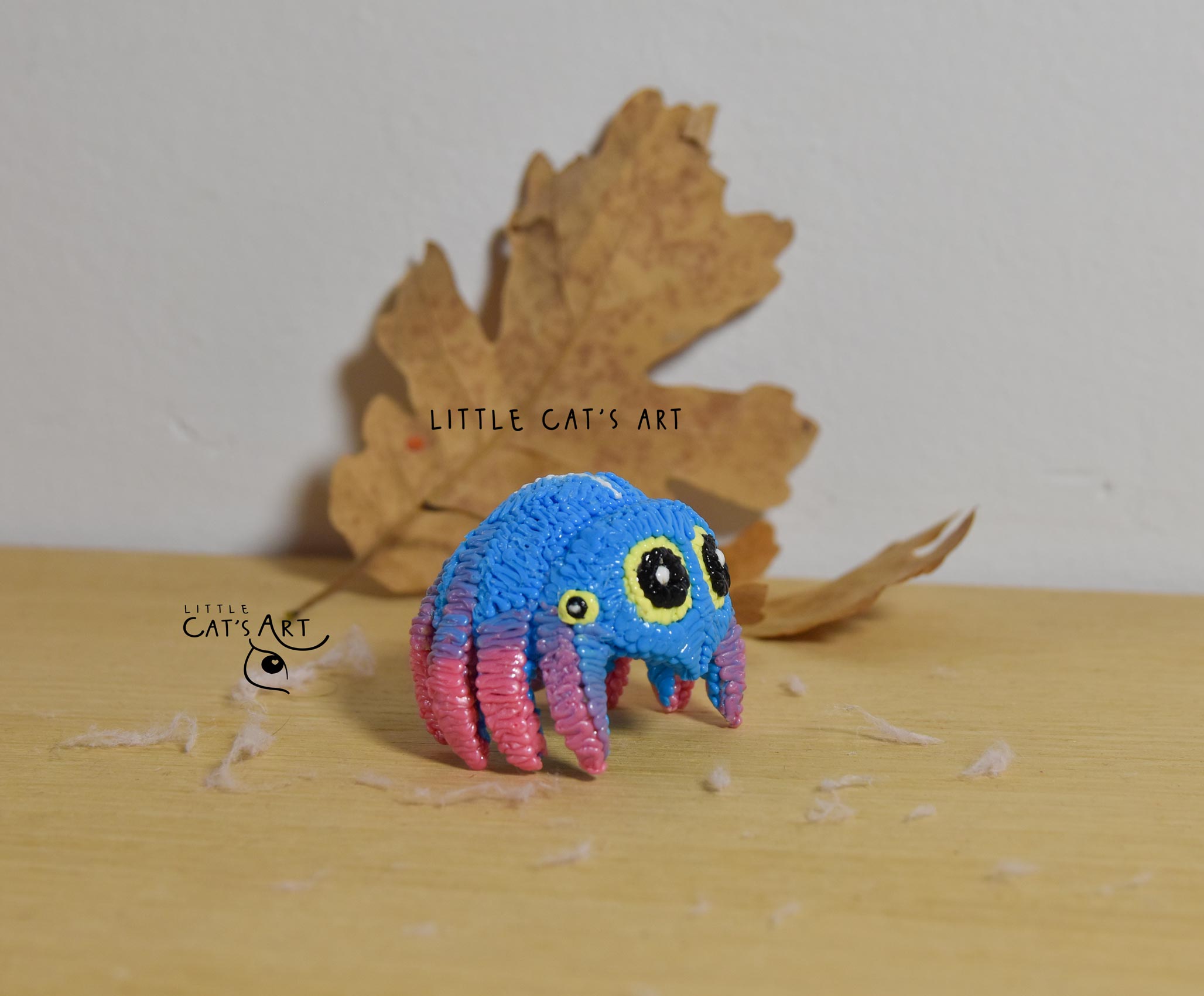 Little blue-pink spidey figurine with yellow eyes