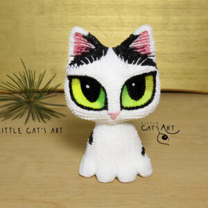 Black and white cat figurine with yellow-green eyes