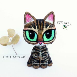 Stripey tabby cat figurine with big green eyes